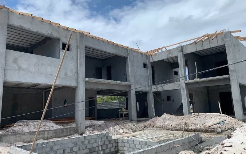 Construção de prédio em andamento, com céu nublado.