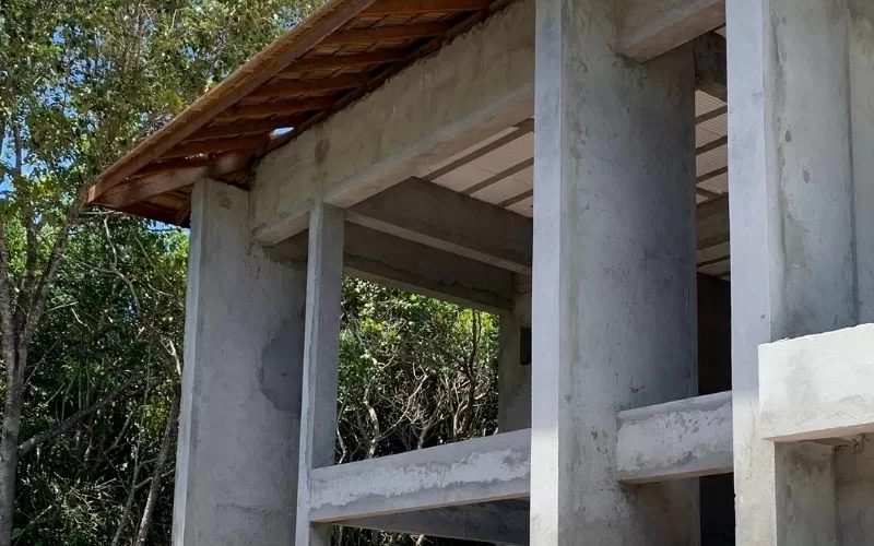Obra em construção com paredes de cimento armado.