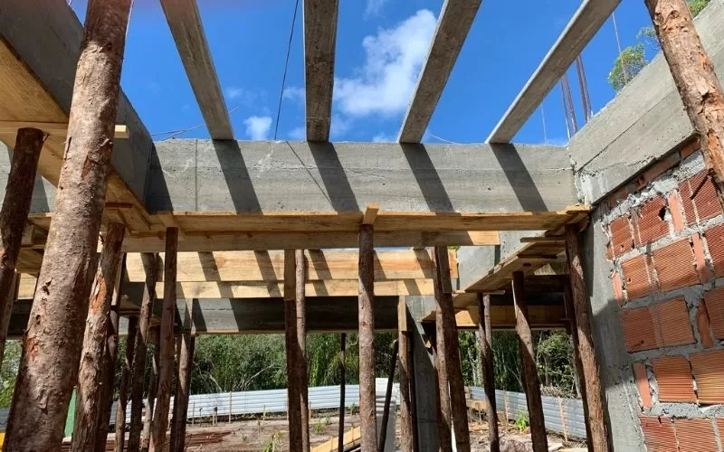 Estrutura de betão em construção com suportes de madeira.