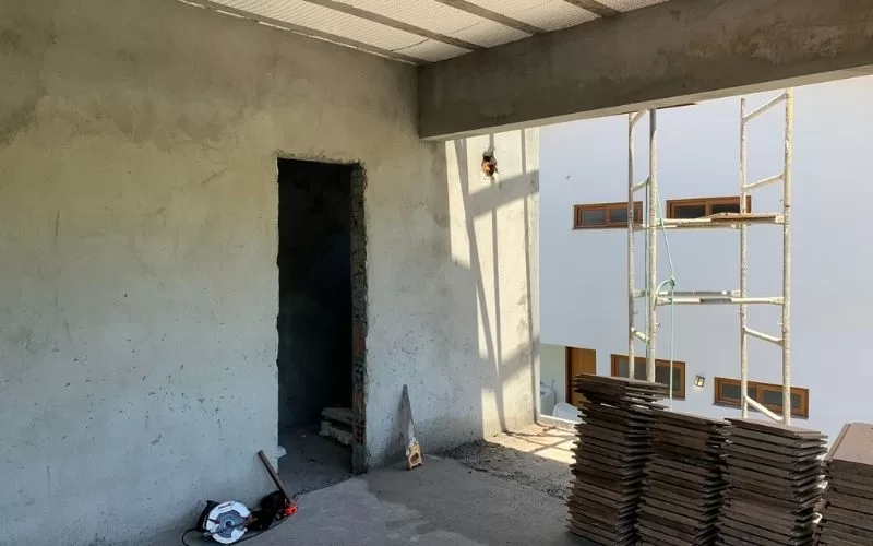 Interior de obra em construção com materiais e andaimes.