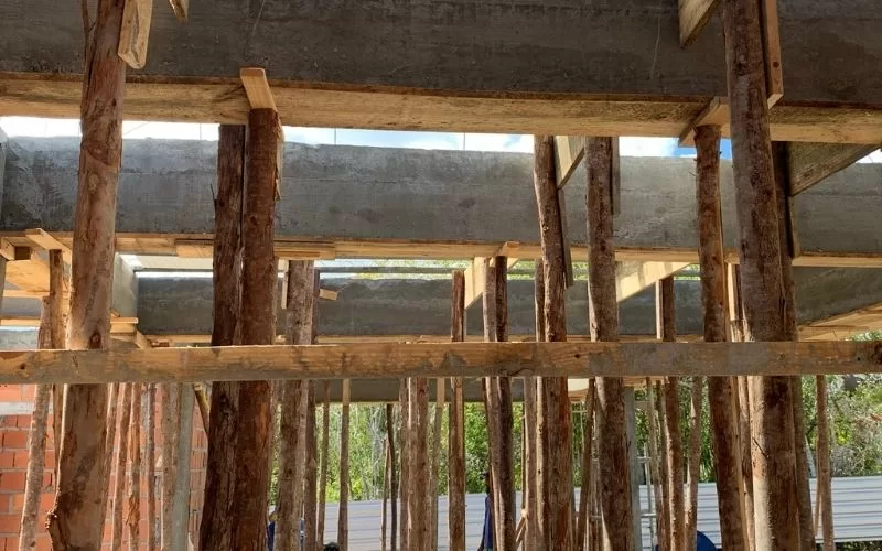Construção com vigas de madeira e betão armado.