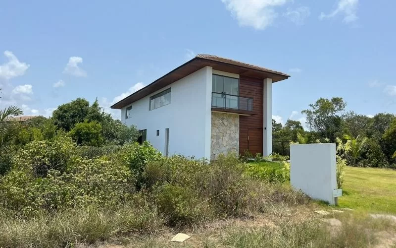 Casa moderna numa paisagem verde e céu azul.