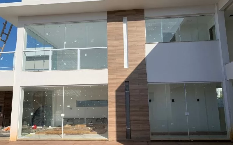 Fachada moderna de casa com vidro e madeira.