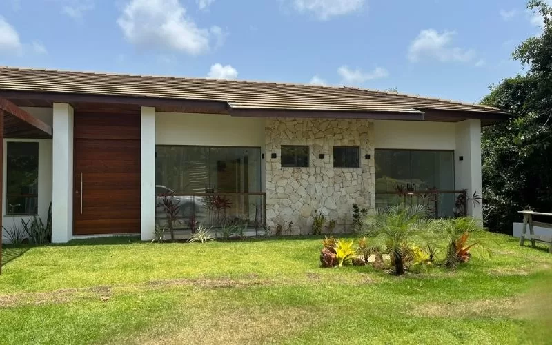 Casa moderna com jardim e fachada de pedra.