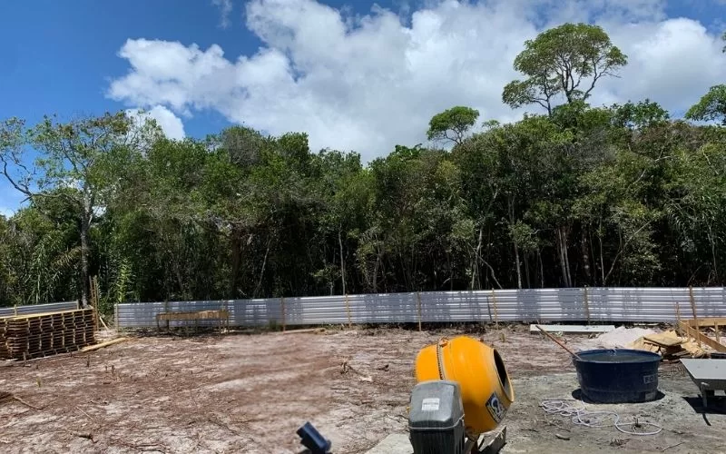 Terreno em construção com floresta ao fundo.