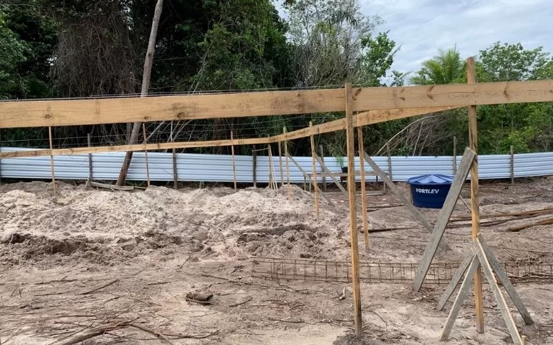 Obra de construção com cercas e madeira.