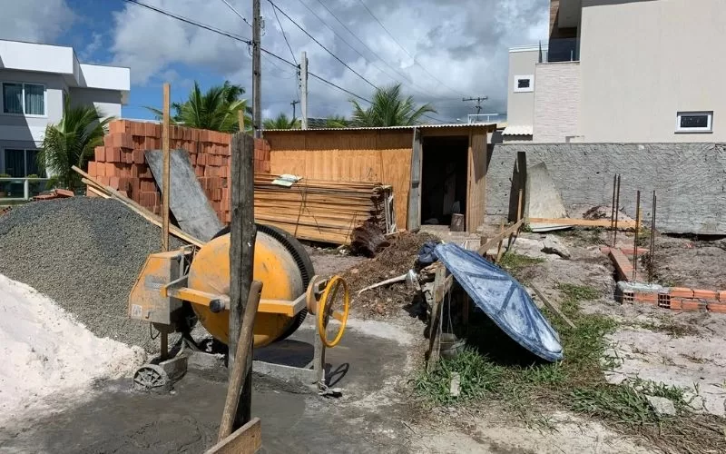 Obra em construção com betoneira e materiais.