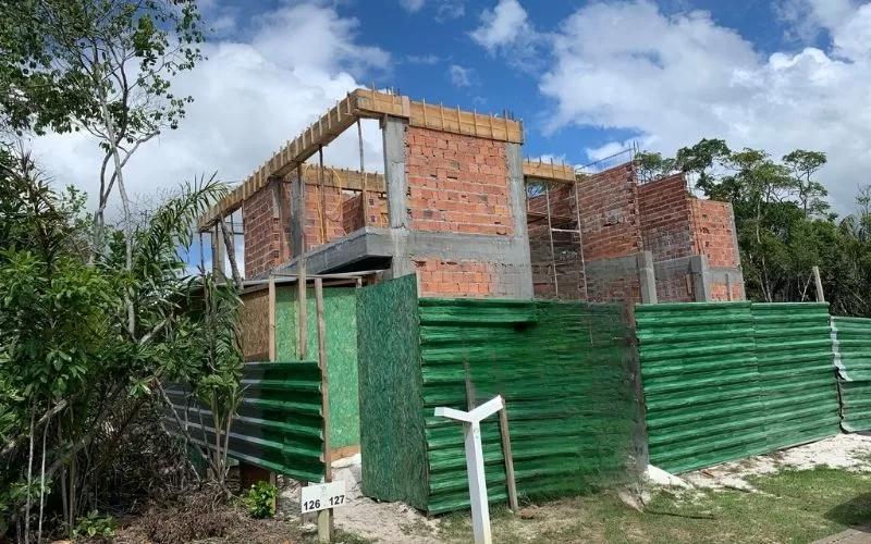 Construção de edifício em andamento com tijolos expostos.