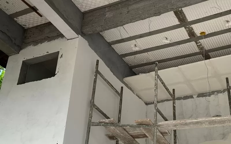 Reforma de teto com andaimes e perfis metálicos.