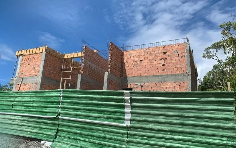 Obra de construção com paredes de tijolos visíveis.