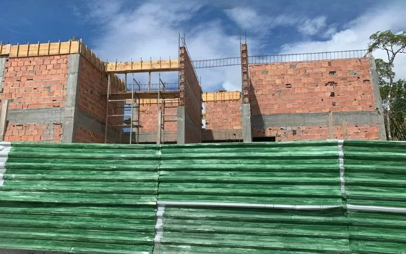 Construção de edifício em andamento com tijolos expostos.