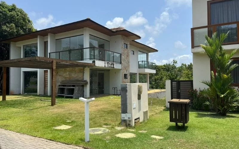 Casa moderna com jardim e varanda ensolarada.