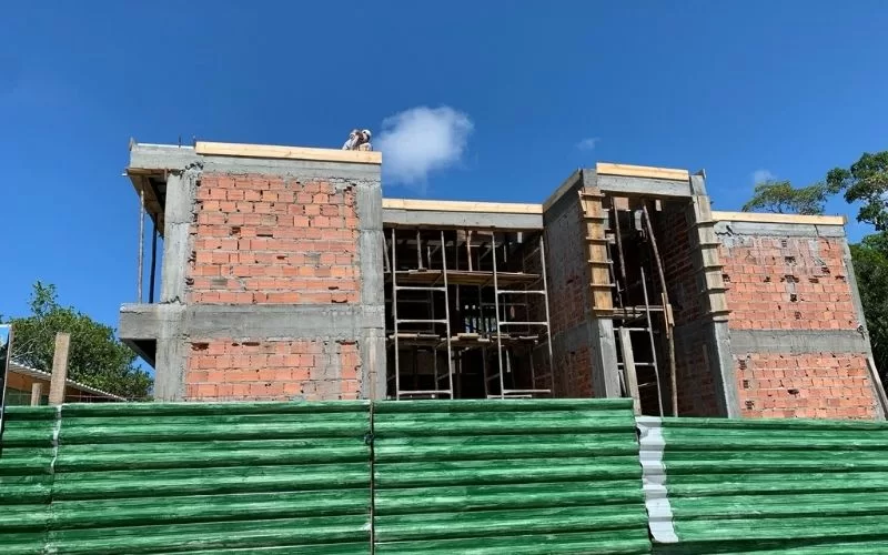 Construção de prédio com tijolos aparentes e andaimes metálicos