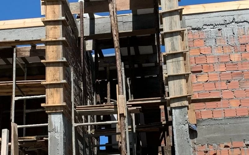 Construção de edifício com estrutura de madeira e tijolos.