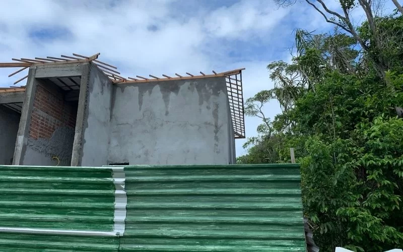 Construção inacabada cercada por vegetação.