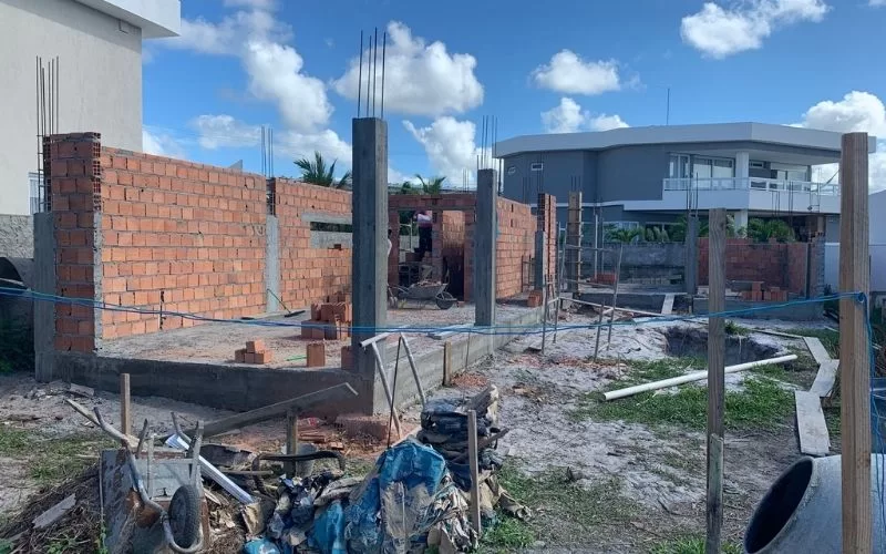 Construção de casa em fase inicial, tijolos expostos.