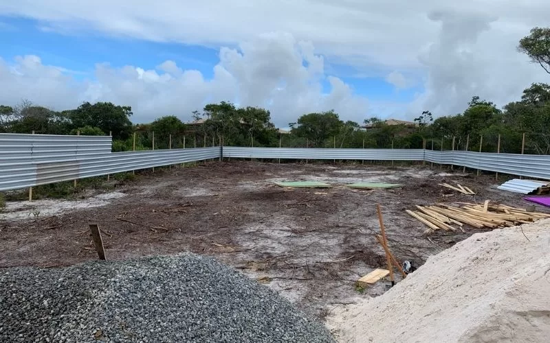 Terreno vazio cercado por chapas metálicas.