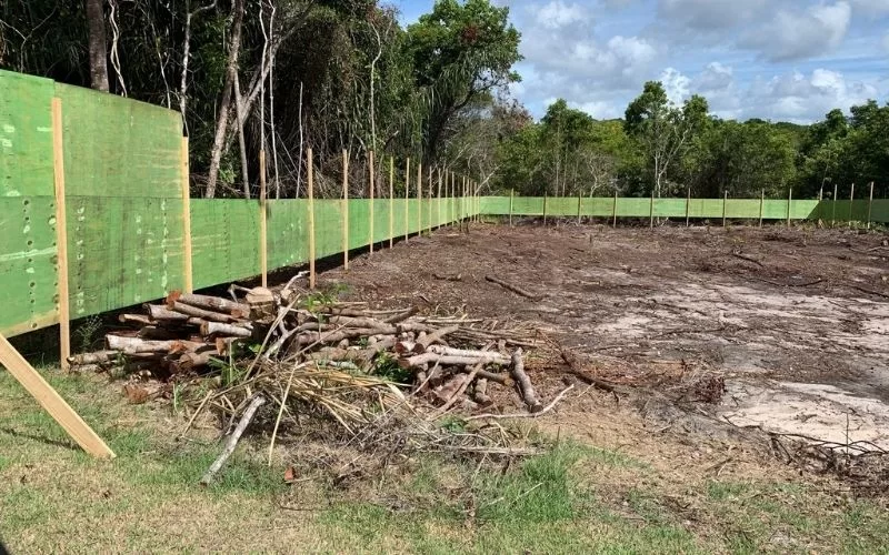 Área desmatada com cerca de madeira em construção.