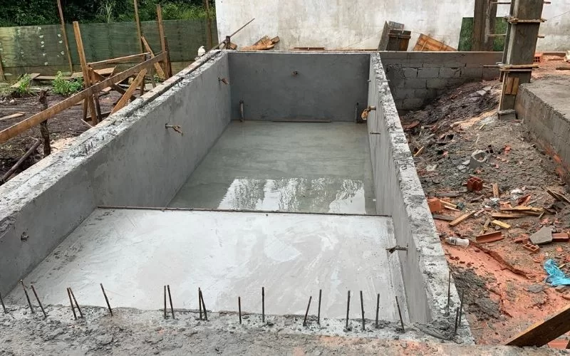 Construção de piscina de concreto em andamento.