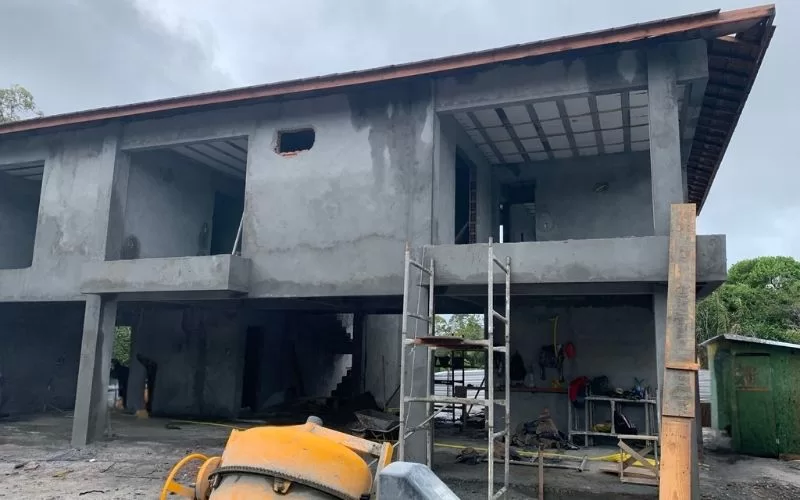 Construção de edifício em fase inicial, andaimes visíveis.